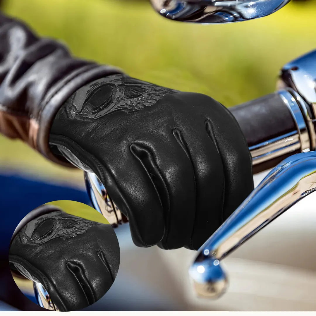 Black leather glove with intricate design on a motorcycle handlebar
