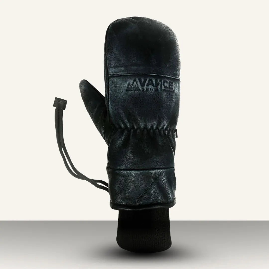 Winter Mountaineering Mittens in black leather with ribbed cuff and adjustable strap for outdoor snow activities.